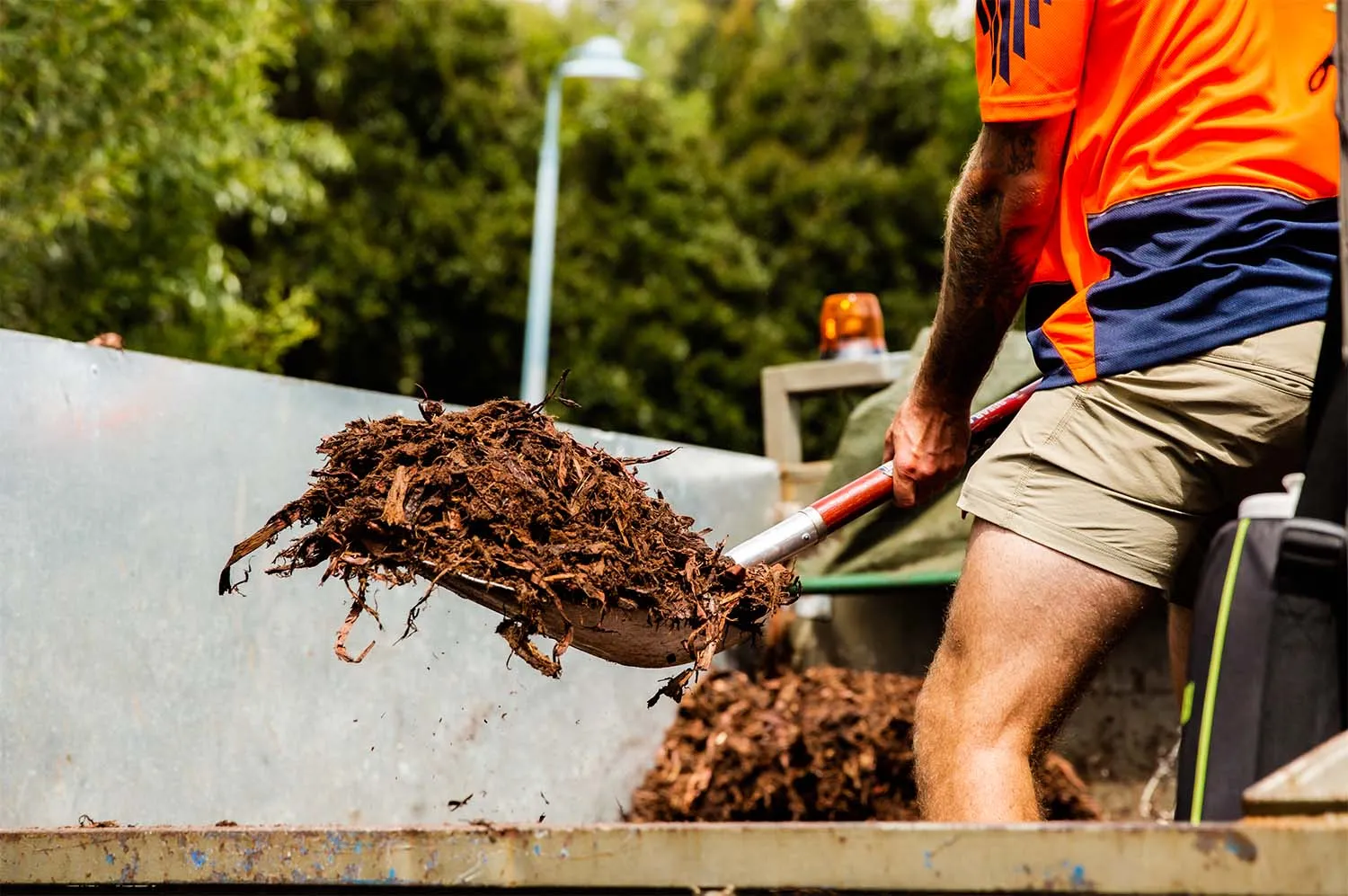 Shovelling bark mulch in the back of the AutoMulch truck